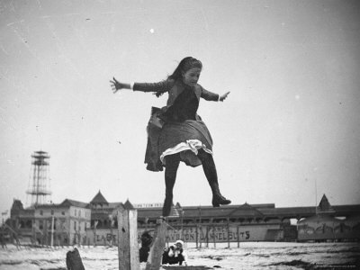 Young Edith Poey Jumping Off A Wooden Pole Onto The Sand At Coney Island by Wallace G. Levison Pricing Limited Edition Print image