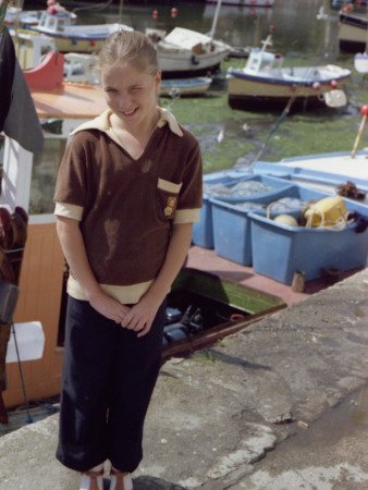 A Little Girl Stands By The Fish Harbour In Kingsbridge, Devon by Vanessa Wagstaff Pricing Limited Edition Print image