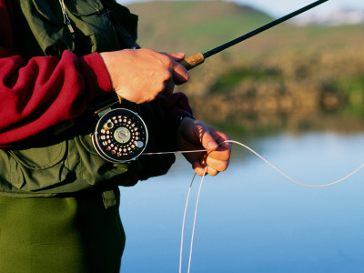 A Man Holding A Fishing Rod And Pulling The Line Out Of The Reel by Bragi Thor Josefson Pricing Limited Edition Print image