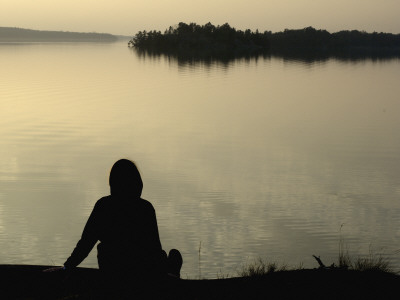 Silhouette Of A Woman Sitting At The Lakeside, Lake Malaren, Sweden by Ewa Lundgren Pricing Limited Edition Print image
