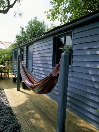 Blue Summerhouse With Decking, Hammock, Birch Tree Trunks And Purple Slate Mulch by Clive Nichols Pricing Limited Edition Print image