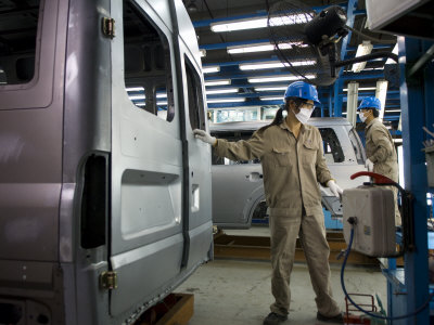 Workers Move Vehicles Along The Assembly Line At Ford Vietnam by Steve Raymer Pricing Limited Edition Print image