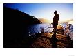 Man On Dock Silhouetted At Sunrise At Bahia Mansa, Lake Nahuel Huapi, Villa La Angostura, Argentina by Michael Taylor Limited Edition Print