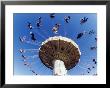 Blurry Colorful Amusement Park Ride With People Against A Bright White Sky by Guy Crittenden Limited Edition Print