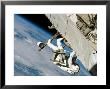An Astronaut Mission Specialist, Crawls Along A Truss On The International Space Station by Stocktrek Images Limited Edition Pricing Art Print