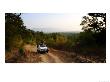 Tiger Tourism, Jeep Travelling With Forest Of Bandhavgarh In Background, Madhya Pradesh, India by Elliott Neep Limited Edition Print