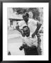 Italian Man Leaping Onto A Friend's Back In Casual Greeting While Crossing A Piazza by Paul Schutzer Limited Edition Print