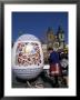 A Moravian Woman Decorating A Large Egg With Easter Designs On The Old Town Square, Prague by Richard Nebesky Limited Edition Print