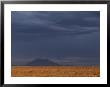 Big Southern Butte Looms In The Distance Under A Dark And Stormy Sky by Michael Melford Limited Edition Print