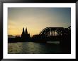 The Cologne Cathedral And Hohenzollern Bridge Silhouetted At Dusk by Raul Touzon Limited Edition Print