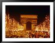 A Night View Of The Arc De Triomphe And The Champs Elysees Lit Up For Christmas by Nicole Duplaix Limited Edition Print
