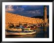 Fishing Boats Docked By Lighthouse Rethymno, Crete, Greece by Glenn Beanland Limited Edition Print