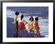 Girls On Lebih Beach, South Of Gianyar, Play Along The Fringe Of Breaking Waves, Indonesia by Adams Gregory Limited Edition Print