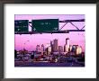 Traffic Signs Over Highway With City Skyline Beyond At Dusk, Minneapolis, United States Of America by Richard Cummins Limited Edition Print