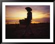 A Snack And Cigarette Vendor In A Straw Hat On The Beach At Dusk by Eightfish Limited Edition Print
