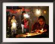 A Woman Lights Earthen Lamps As Children Ignite Firecrackers In New Delhi by Manish Swarup Limited Edition Print