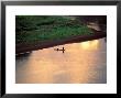 Sunset On Karo Men In A Dugout Raft, Omo River, Ethiopia by Janis Miglavs Limited Edition Print