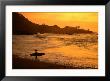 Surfer Standing At Waimea Bay At Sunset, Waimea, U.S.A. by Ann Cecil Limited Edition Print