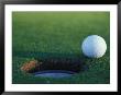 Golf Ball Poised At Edge Of Hole by Fogstock Llc Limited Edition Pricing Art Print