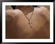 A Silver Crucifix Hangs From A Chain On The Back Of A Shirtless Boy by Randy Olson Limited Edition Print