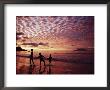 Sunset Reddens A Cloudy Sky As Silhouetted Children Play On The Beach by Steve Raymer Limited Edition Print