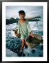 A Girl Gathers Salt Water In Lontar Leaf Buckets For Salt Making, Kusamba, Indonesia by Adams Gregory Limited Edition Print