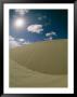 Sunlight And Puffy Clouds Over Huge Sand Dunes With Animal Tracks by Wolcott Henry Limited Edition Pricing Art Print