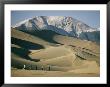 Hikers Among The Sand Dunes With A Snow-Covered Mountain Rising In The Background by Walter Meayers Edwards Limited Edition Pricing Art Print