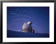 Time-Exposure Of The Mauna Kea Observatory Taken At Night, The Streaks In The Sky Are Star Trails by Robert Madden Limited Edition Print