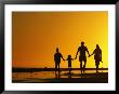 A Family Holding Hands Is Silhouetted Against The Setting Sun by Rich Reid Limited Edition Pricing Art Print