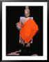 Standing Buddha Statue In Orange Cloth, In Outer Gallery At Angkor Wat, Angkor, Cambodia by Tom Cockrem Limited Edition Pricing Art Print