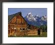 Weathered Wooden Barn Along Mormon Row With The Grand Tetons In Distance, Grand Teton National Park by Dennis Flaherty Limited Edition Print