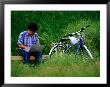 Man Using Laptop Computer Beside His Bicycle Near Kamogawa River, Kyoto, Japan by Frank Carter Limited Edition Print