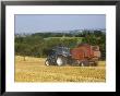 Tractor Collecting Hay Bales At Harvest Time, The Coltswolds, England by David Hughes Limited Edition Print