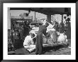 Muller Brothers Service Station's Attendants Pumping Gas And Inflating Tires On A Fancy Convertible by Peter Stackpole Limited Edition Print