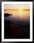 Two Empty Wooden Chairs Sit On Maine's Rocky Coast As The Sun Sets Over The Horizon by Tim Laman Limited Edition Print