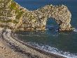 People Sitting On The Beach Beside Durdle Door Natural Rock Arch, Dorset, England, United Kingdom by Adam Burton Limited Edition Print