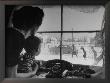Mother And Child Looking Out Window As Father And Older Brothers Walk To Car In Snow by Alfred Eisenstaedt Limited Edition Print