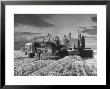 Combines And Crews Harvesting Wheat, Loading Into Trucks To Transport To Storage by Joe Scherschel Limited Edition Print