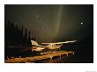 The Aurora Borealis Glows Brightly Over A Seaplane Docked On Cli Lake by Raymond Gehman Limited Edition Print