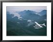 A Beaver Airplane On Floats Flies Over Islands And Snowy Mountains by Joel Sartore Limited Edition Print