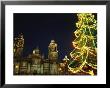A Night View Of A Lighted Christmas Tree Near An Old Building by Raul Touzon Limited Edition Print