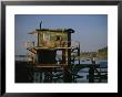 A Man Sits On A Pier Near A Dilapidated Shack by Raymond Gehman Limited Edition Pricing Art Print
