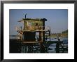 A Man Sits On A Pier Near A Dilapidated Shack by Raymond Gehman Limited Edition Print