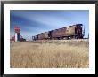 Grain Elevators And Wheat Train, Saskatchewan, Canada by Walter Bibikow Limited Edition Print