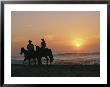 Two People On Horseback Ride Along An Ocean Shoreline At Sunset by Roy Toft Limited Edition Print