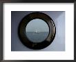 A Porthole Provides A Brass Frame For A Passing Sailboat by Stephen St. John Limited Edition Print
