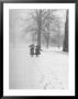 Snow Falling While People Take A Stroll Across Campus Of Winchester College by Cornell Capa Limited Edition Pricing Art Print