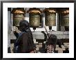 Buddhist Woman And Child Spin Brass Prayer Wheels, Qinghai, China by David Evans Limited Edition Print