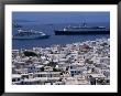 Cruise Ships Passing Houses Of Town, Mykonos Town, Greece by Wayne Walton Limited Edition Print